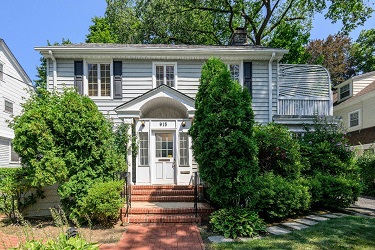 white two-story home with shrubs