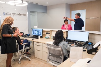 Dental office front desk with staff and patients